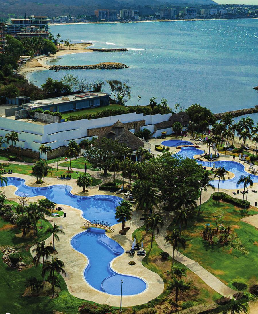 Vista aérea del residencial en La Cruz de Huanacaxtle, con albercas, jardines y la bahía al fondo